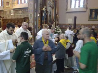 Na I-szym planie Maciek z bloga 1040.pl przyjmuje komunię od ks. Radka, w a głębi bp Kasyna komunikuje brata Żwirka i jego żonę